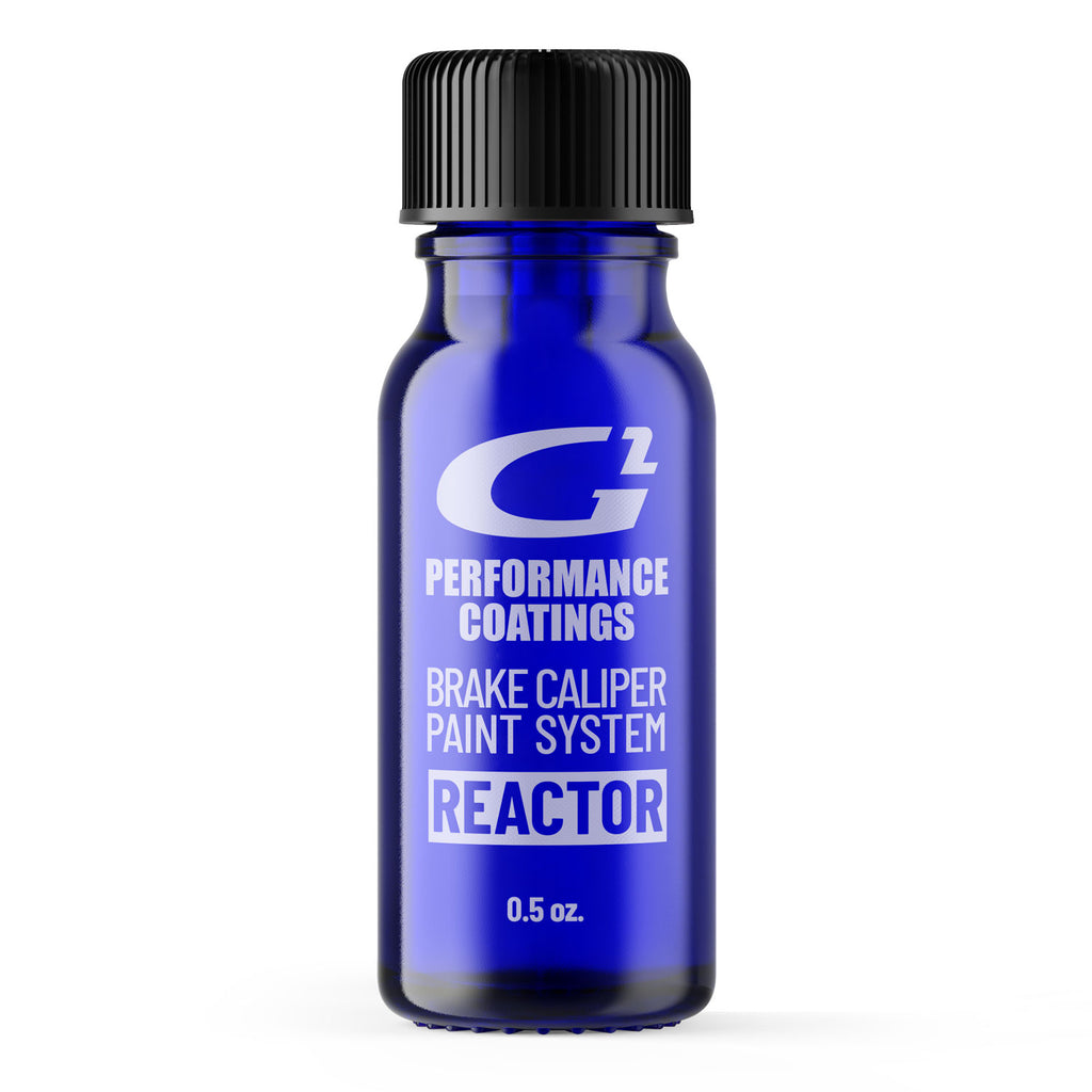 A blue bottle with a black cap labeled as a 'reactor' for a car brake G2 caliper paint system.